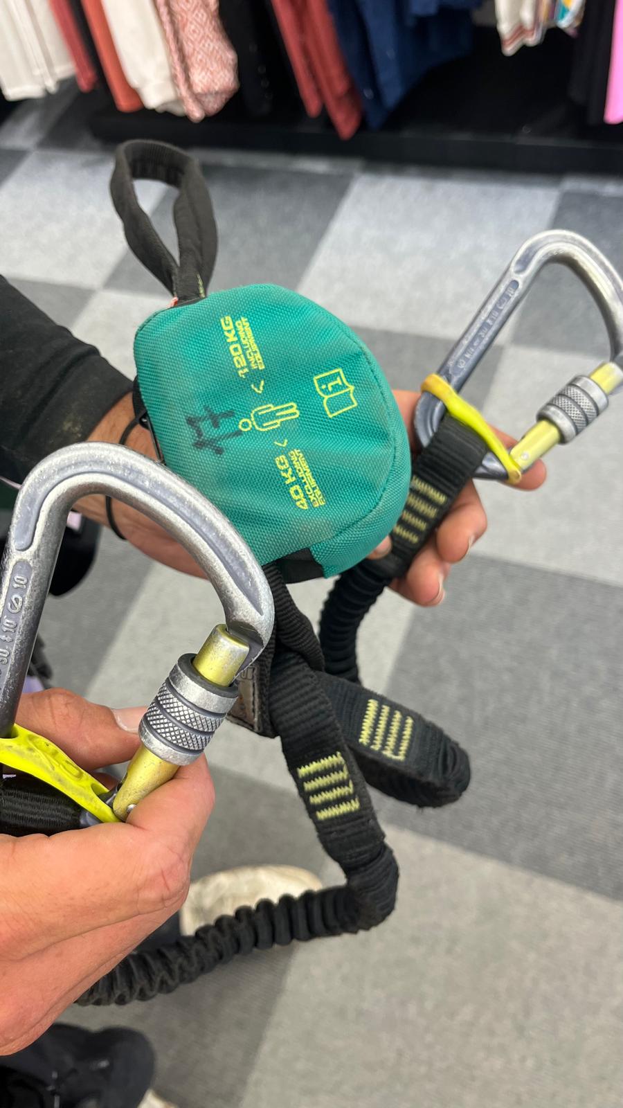 Via ferrata lanyard equipped with two safety carabiners and a green energy absorber.